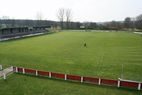 Spielfeld mit rot-weißer Bande und Tribüne
