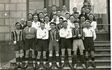 Historisches Gruppenfoto von Spielern in gestreiften und weißen Trikots auf einer Treppe