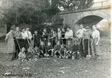 Historisches Gruppenfoto im Freien vor einer Steinbrücke
