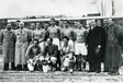 Historisches Mannschaftsfoto mit Begleitern in Mänteln