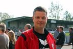 Mann in roter Jacke vor der Tribüne