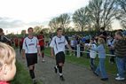 Spieler in weißen Trikots gehen an Zuschauern vorbei