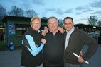 Drei Männer Arm in Arm vor dem Stadion in der Abenddämmerung