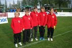 Fünf Kinder in roten Jacken auf dem Spielfeld