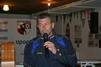 Mann mit Mikrofon im Vereinsheim vor einer Sponsorenwand