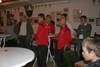 Personen in roten Jacken im Gespräch im Vereinsheim