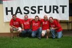Die fünf Fan-Club-Mitglieder knien und hocken auf dem Rasen vor einem weißen Banner mit der Aufschrift „HASSFURT“