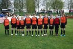 Kindermannschaft in orange-schwarzen Trikots auf dem Spielfeld aufgereiht