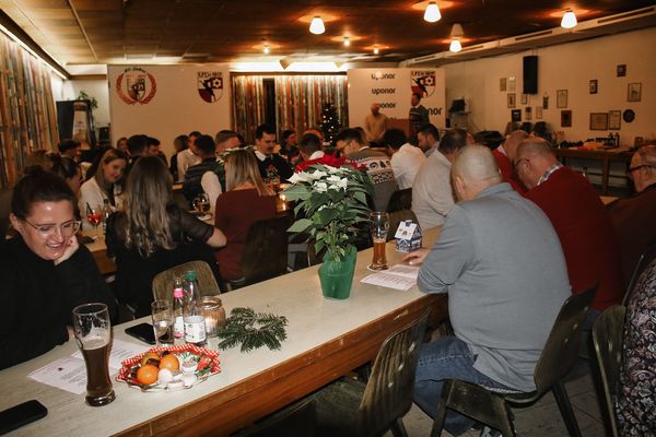 Gäste an gedeckten Tischen im voll besetzten Saal bei der Weihnachtsfeier 2024