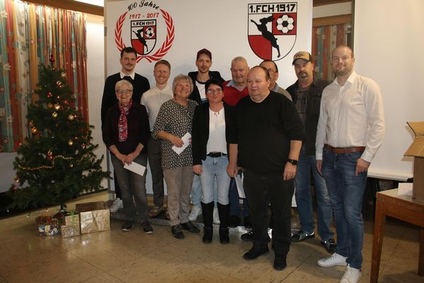 Helferinnen und Helfer bei der Weihnachtsfeier 2025 vor dem Vereinsbanner und dem Christbaum