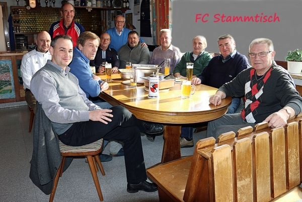 Männerrunde am runden Stammtisch im Vereinsheim, daneben der Schriftzug „FC Stammtisch“