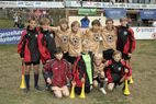Kindermannschaft in beigefarbenen Trikots mit Tröten