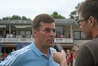Mann im hellblauen Trainingsshirt beim Interview mit Mikrofon