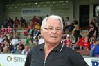 Älterer Mann mit Brille vor der voll besetzten Tribüne