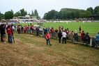 Zuschauer am Spielfeldrand mit Blick auf Spielfeld und Tribüne
