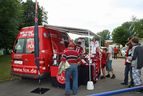 Roter Fanartikel-Wagen des 1. FC Nürnberg mit Fans
