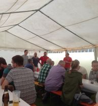 Gäste an Bierbänken in einem Festzelt