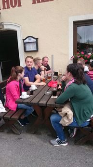 Gruppe an Biertischen vor einem Gasthaus