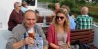 Mann mit Bierglas und Frau mit Sonnenbrille an Deck