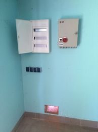Schaltkästen an einer türkisfarbenen Wand in einem Innenraum