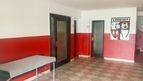 Flur im Vereinsheim mit rot-weiß gestrichenen Wänden und Vereinswappen