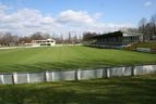 Spielfeld mit Vereinsheim und überdachter Tribüne