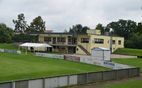 Vereinsheim mit weißem Zelt hinter der Spielfeldbande