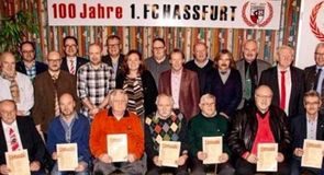 Gruppenfoto geehrter Mitglieder mit Urkunden vor dem Jubiläumsbanner