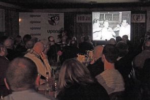 Filmvorführung mit Schwarzweißbildern im abgedunkelten Saal vor Publikum