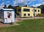 Vereinsheim, davor ein weißes Kassenhäuschen mit Vereinswappen
