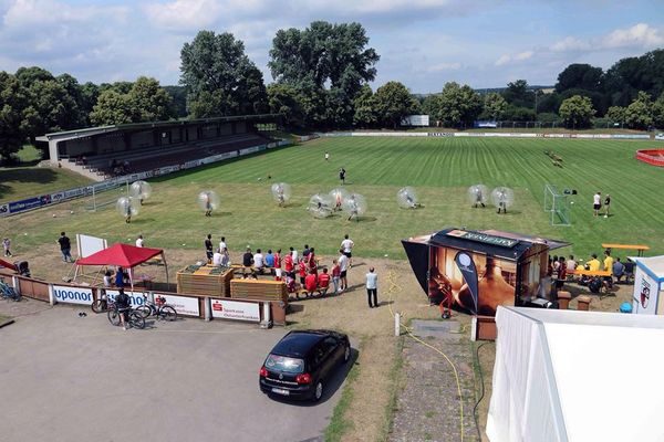 Blick von oben auf das Spielfeld mit aufblasbaren Loopyball-Bällen und Zuschauern